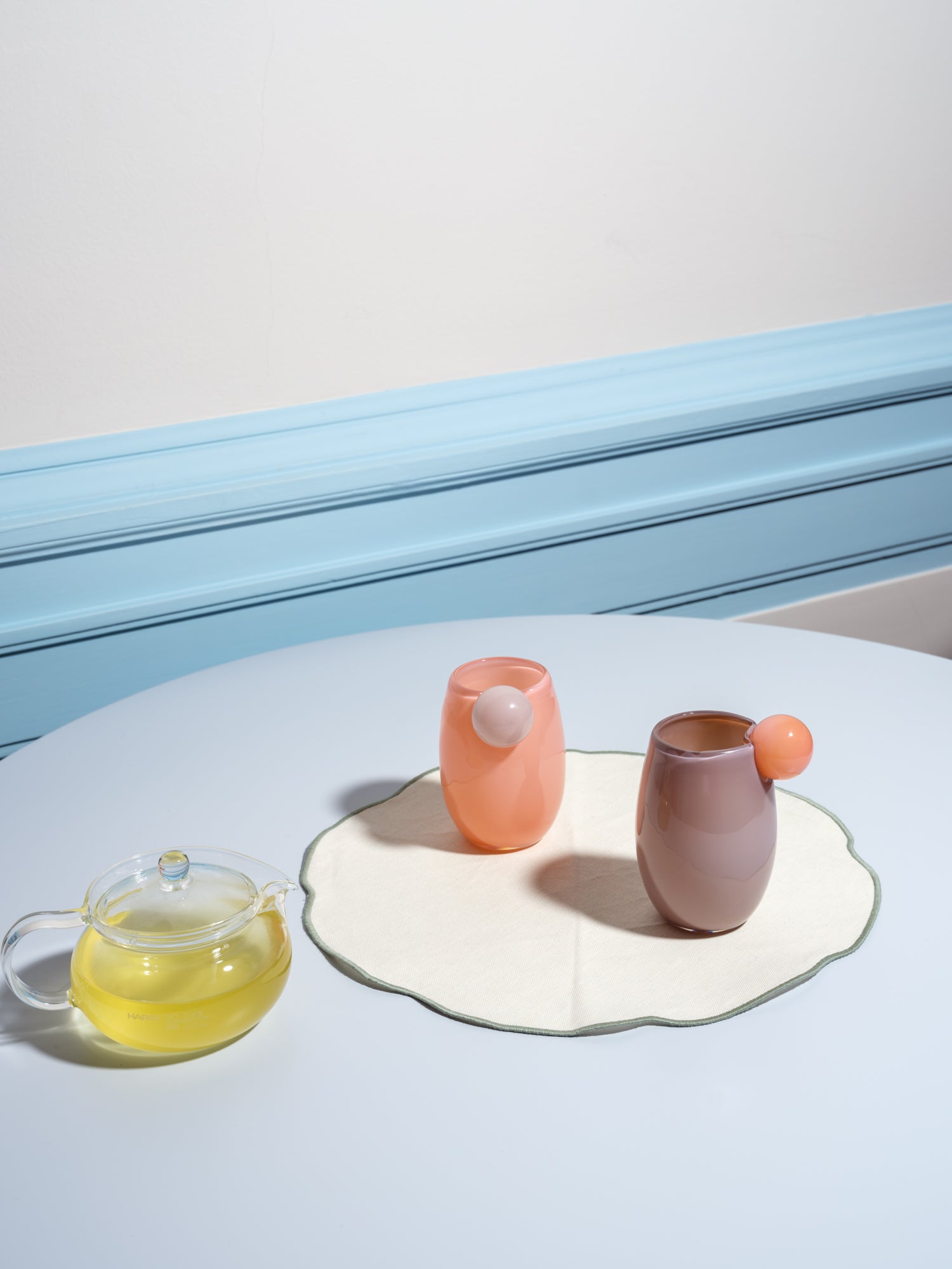 Cup made of glass with a ball on the side in light pink and purple