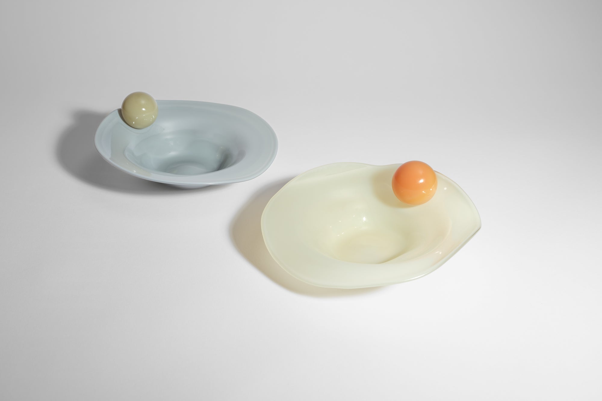 two breakfast bowls with a ball on the side in yellow, blue, orange and white
